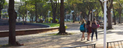 Três estudantes vistas de costas caminhando juntas em praça da Unicamp
