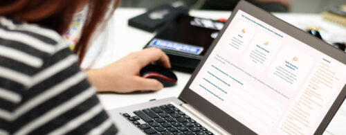 Pessoa no notebook acessando o Manual de Gerenciamento de Frequência e Férias