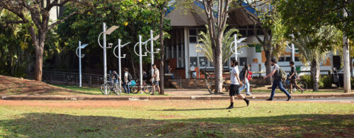Vários estudantes andando por ambiente externo da Unicamp