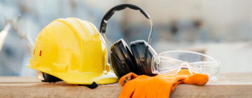 Capacete amarelo, fones de proteção auricular e óculos de proteção
