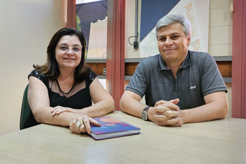 Cidinha e Everaldo sentados à mesa de reuniões.